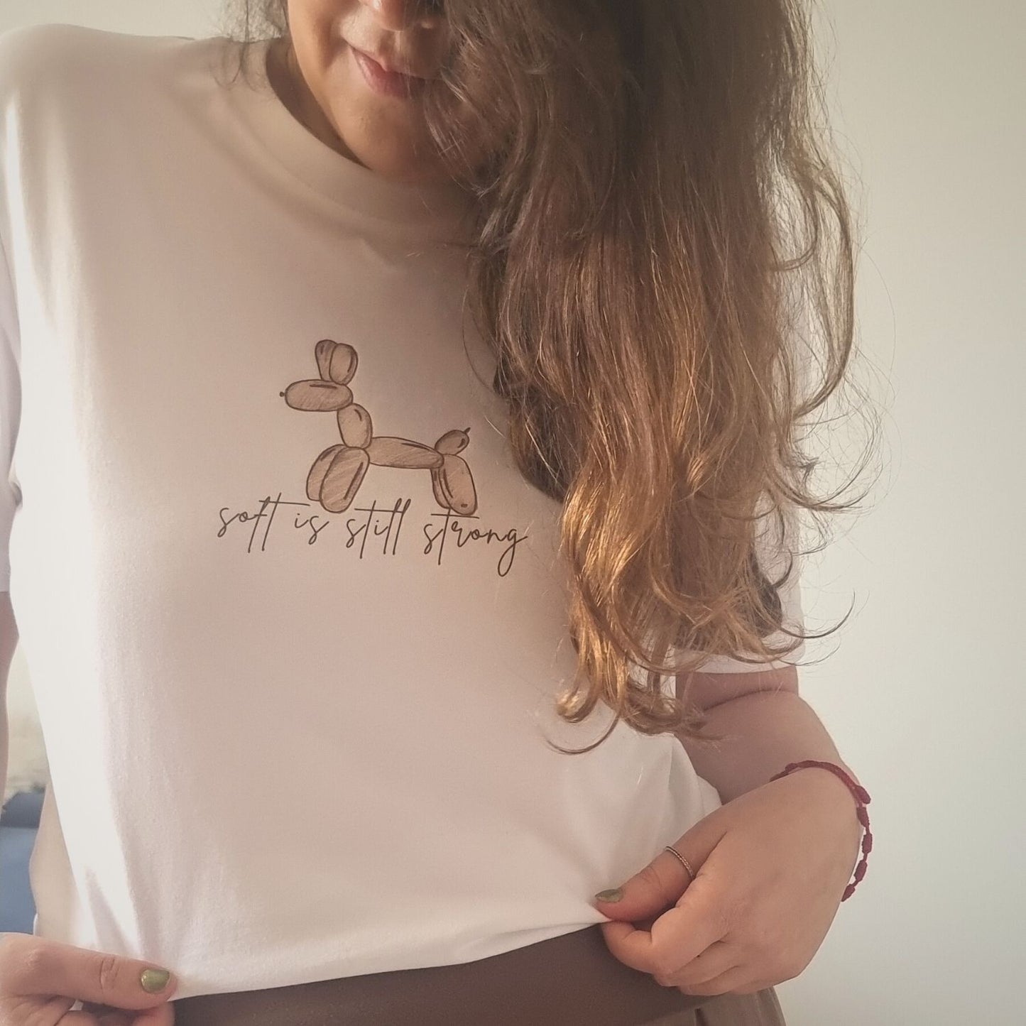 Soft Organic Cotton T-shirt in white with hand-drawn balloon dog and Soft Is Still Strong front print