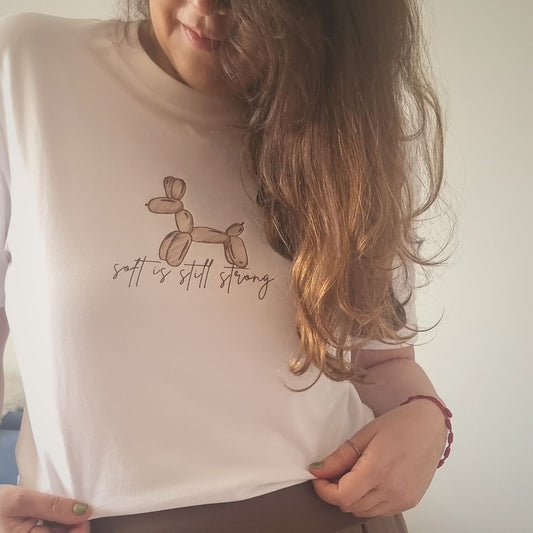 Soft Organic Cotton T-shirt in white with hand-drawn balloon dog and Soft Is Still Strong front print